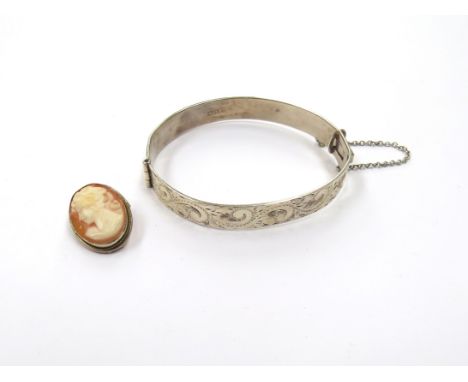 A silver engraved bangle and a cameo brooch