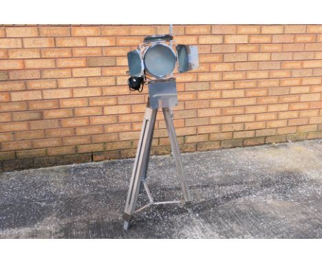 A floor lamp in the form of a nickel plated movie light with four shutters, raised on wooden tripod support, approximately 97