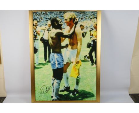 A Reproduction Canvas Print of Pele and Bobby Moore, hand signed by Pele, framed, 88cm by 61cm, with certificate of authentic