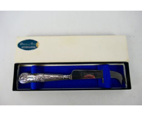 A silver handled cheese knife in original box. Sheffield assay 1983. Harrison Brothers makers mark. Stainless steel blade. Ap