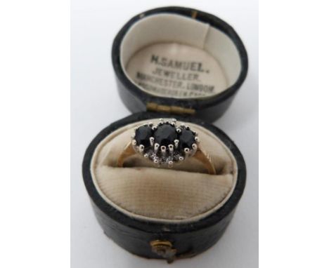 A vintage three stone sapphire and diamond ring in an antique leather effect ring box. Set with three oval mixed cut sapphire