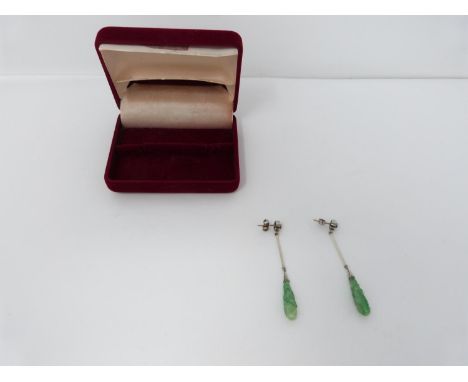 A pair of Art Deco style carved jade, diamond and white metal and 9ct gold drop earrings. The earrings set with two round old