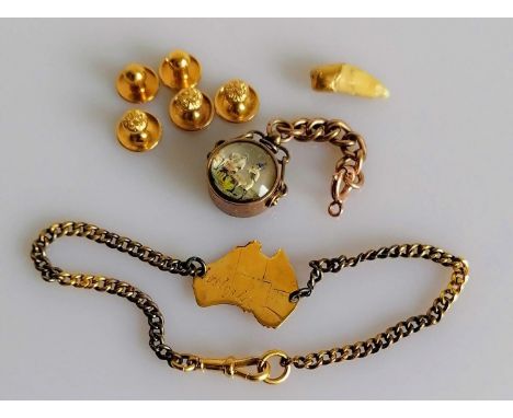 An assortment of 9ct gold items to include compass, map of Australia, hallmarked and five dress shirt buttons, unmarked but t