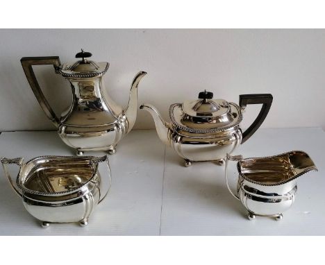 An Edwardian four-piece silver tea and coffee service with fruitwood harp handles, leaf scroll decoration, gadroon rims on ba