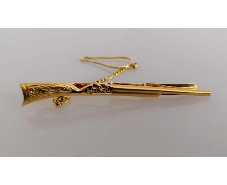 A yellow gold tie clip in the form of a rifle with safety chain, stamped 585, 6 cm, 6.78g