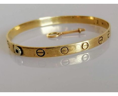 A 9ct yellow gold love bangle with key, import marks, 65mm x 55mm, 14.3g