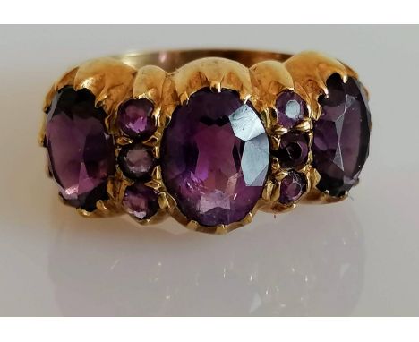 A mid-century 9ct yellow gold three-stone amethyst dress ring, largest 10mm x 8mm; 8mm x 5mm smaller, size R, hallmarked, 6.4