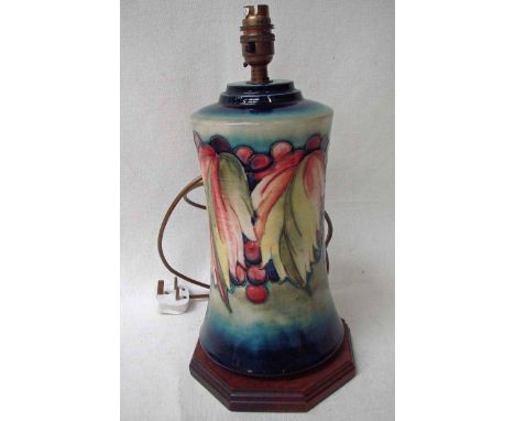 A Moorcroft pottery table lamp base, tubeline decorated in the Leaf and Berries pattern on a graduating blue ground, set on a