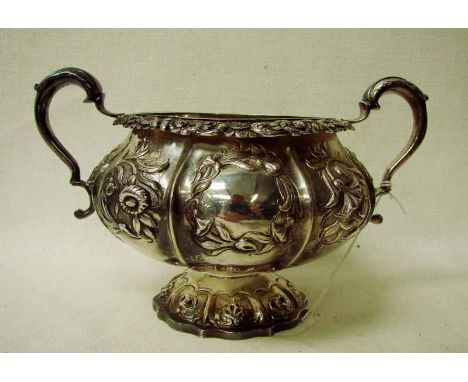 A George IV Regency silver two-handled sucrier, of typical cylindrical form, embossed with foliage, reserved with opposing ca