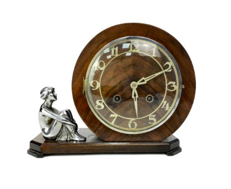 ART DECO MAHOGANY FIGURAL MANTEL CLOCK, with two train movement, Arabic numerals and arrow form hands, the base mounted with 