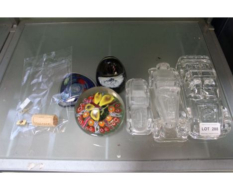 Six various glass paperweights, three being vehicular, together with two similar tie pins