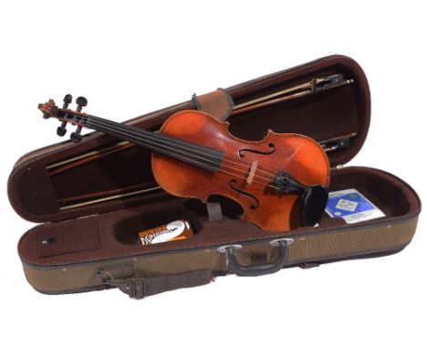 A GERMAN VIOLIN with two piece back and printed label inscribed 'Copie of Stradivarius' together with two bows, one stamped '