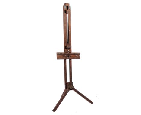 AN OAK EASEL of typical form with folding legs adjusting by an iron wing nut, approximately 186cm high