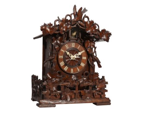 A Black Forest carved wood cuckoo table clock Attributed to Johann Baptist Beha   A Black Forest carved wood cuckoo table clo