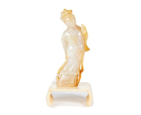 A CHINESE MUTTON FAT AND YELLOW JADE CARVING OF GUANYIN, 3 1/2 ins high with scroll edge ivory stand.   £100-£150