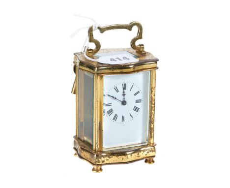 AN EARLY 20TH CENTURY FRENCH BRASS 8 DAY CARRIAGE CLOCK with white enamel dial in a serpentine sided case, 4 1/2 ins high.   