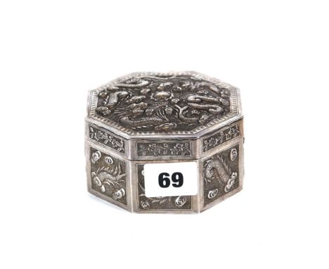 A 19TH CENTURY CHINESE WHITE METAL BOX AND COVER of octagonal form decorated with dragons, seal marks to base, 4 ins diameter