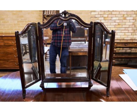 A 1920/30'S MAHOGANY TRIPTYCH MIRROR, foliate urn carved frame raised on paw feet, 35 ins high.   £30-£50