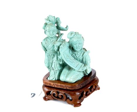 A CHINESE CARVED TURQUOISE GROUP of a kneeling girl with a scroll and a boy with a lily, 3 ins high with wooden base.   £80-£