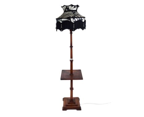 AN ART DECO MAHOGANY STANDARD LAMP with centre tier raised on a square stepped base, complete with shade.   £25-£40