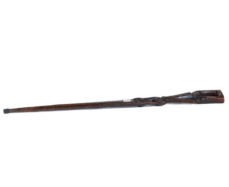 A VINTAGE AFRICAN WOOD RIFLE FORM WALKING STICK carved with a crocodile and two human heads, 39 ins long.   £60-£100