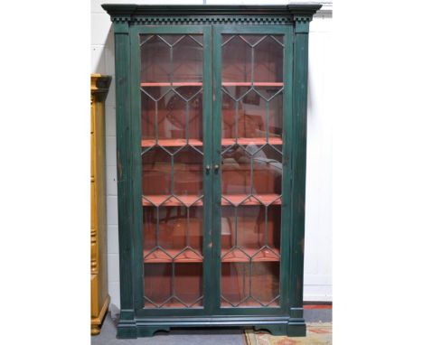 Large painted bookcase, inverted breakfront moulded cornice, above a key frieze, glazed doors enclosing fixed shelves, bracke