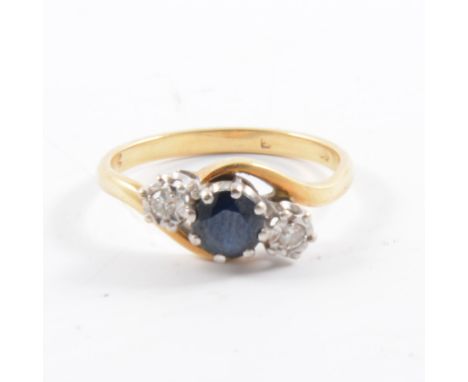 A sapphire and diamond three stone ring, the sapphire claw set and diamonds illusion set in a yellow and white metal crossove