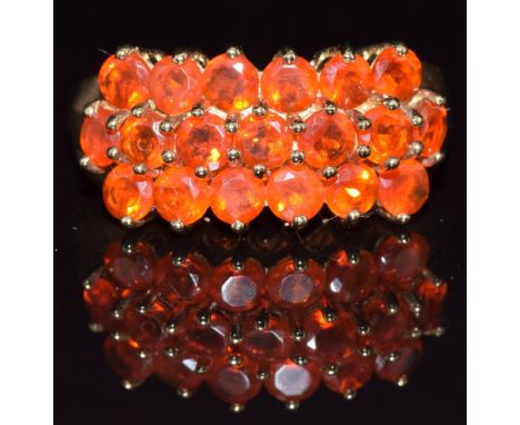 A 9ct gold ring set with round cut fire opals in three rows, 3.5g, size N