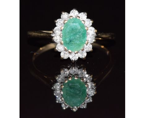 A 9ct gold ring set with an oval cut emerald surrounded by diamonds, 1.8g, size K/L