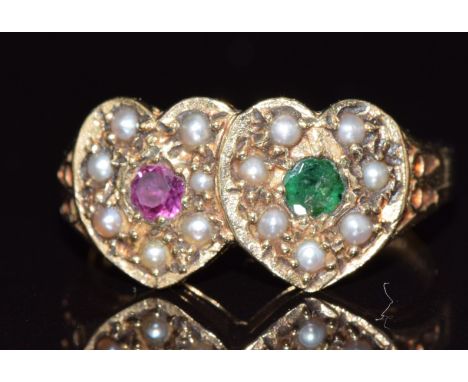 A 9ct gold ring in the form of two hearts set with a ruby, emerald and seed pearls, 3.2g, size M