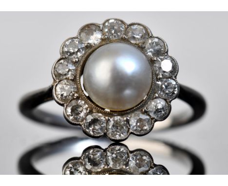 A c1910 platinum ring set with a natural pearl measuring approximately 6.8mm surrounded by diamonds, 2.9g, size J