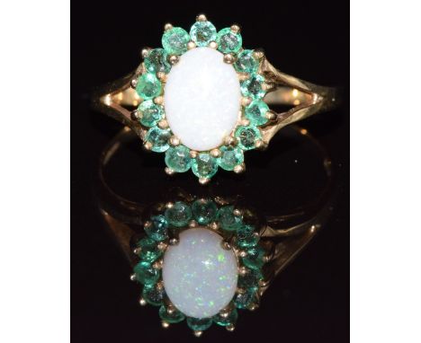 A 9ct gold ring set with opal surrounded by emeralds, 2.1g, size P