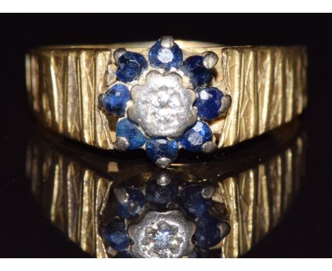 An 18ct gold ring set with a diamond and sapphires, 5g, size R