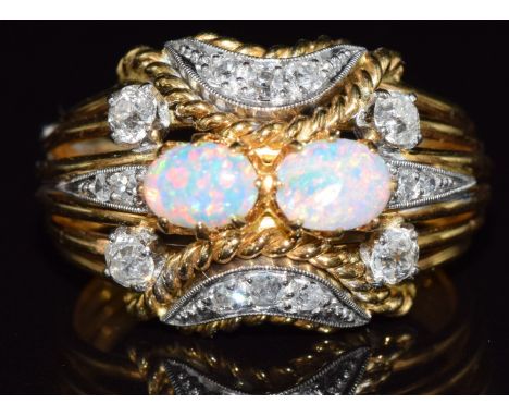 An 18ct gold ring set with two opal cabochons and old cut diamonds, 6.6g, size J