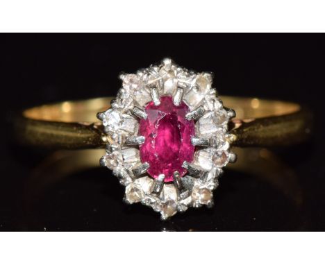 An 18ct gold ring set with a ruby surrounded by diamonds, 2.5g, size O