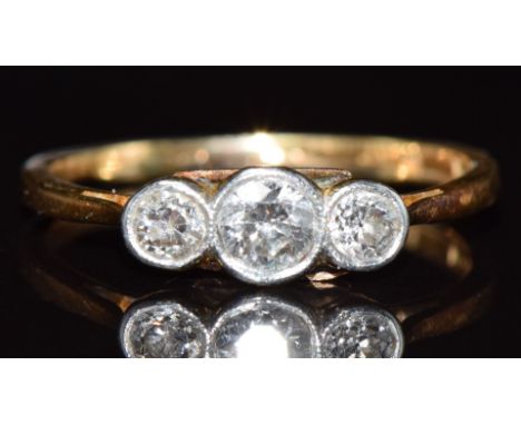 An 18ct gold ring set with three diamonds in a platinum setting, the largest approximately 0.18ct, 2g, size K