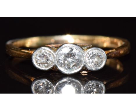 An 18ct gold ring set with three diamonds in a platinum setting, the largest approximately 0.18ct, 2g, size K