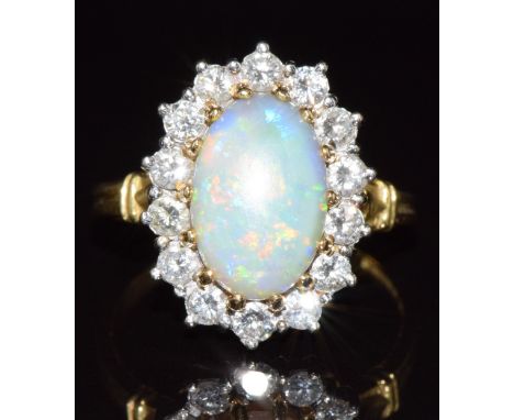 An 18ct gold ring set with an opal cabochon of approximately 1.8ct surrounded by diamonds, 6g, size O