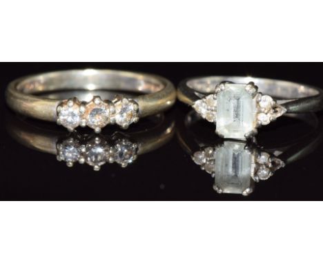 A 9ct gold ring set with an aquamarine and diamonds and a 9ct gold ring set with three diamonds totalling approximately 0.25c