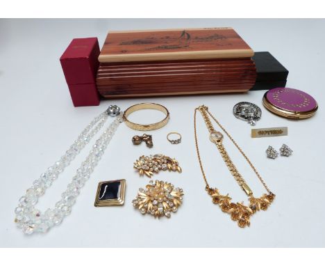 A collection of costume jewellery including rolled gold bangle, brooches, necklace, Stratton compact, silver charms, etc