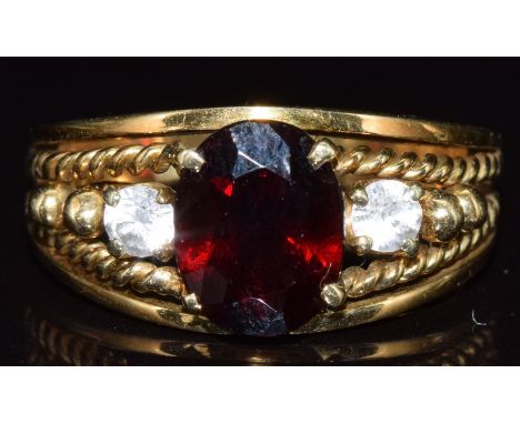 A 14k gold ring set with with a garnet and topaz, 5.6g, size N