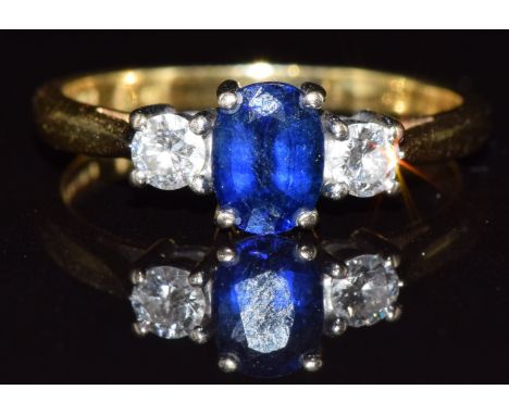 An 18ct gold ring set with an oval cut sapphire of approximately 0.5ct and diamonds, 2.8g, size K