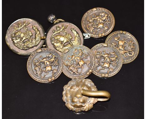Seven Japanese Meiji period metal buttons with decoration in relief and a figural lion clasp, largest diameter 4cm