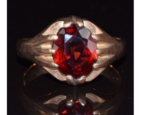 A 9ct gold ring set with an oval cut garnet, 5.2g, size R