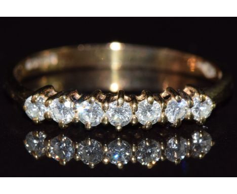 A 9ct gold ring set with seven diamonds, 1g, size L