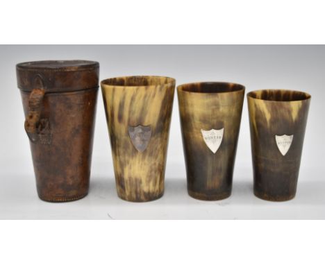 Cased set of three 19thC graduated horn hunting cups in leather case each cup with silver shield shaped plaques engraved 'Nun