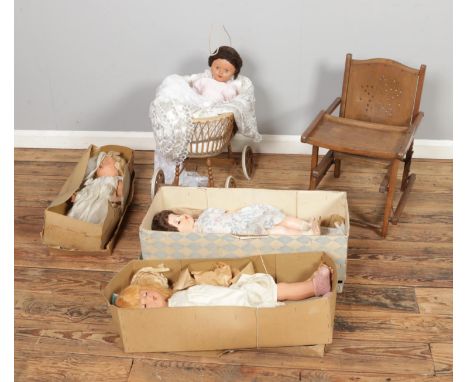A collection of mostly 1950's composition dolls, some boxed, along with a vintage high chair and dolls pram. One doll stamped