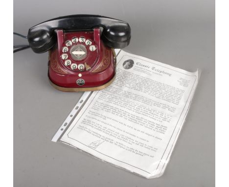 A vintage Rotary Bell Telephone by the MFG Company in red along with original Classic Telephony information sheets.