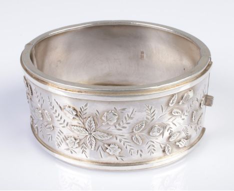 A Victorian silver hinged bangle decorated with floral motifs. Hallmarked for Birmingham 1883, 38.8g.