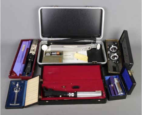 Six boxed vintage optician tools: Perkins tonometer, Heine ophthalmoscope and otoscope, Keeler ophthalmoscope, glasses optome